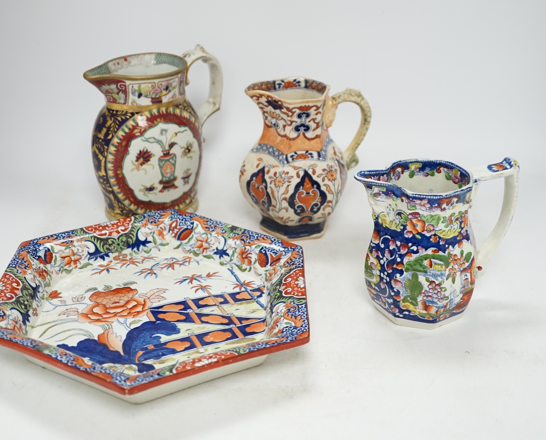 Seven ironstone items, comprising five jugs, a hexagonal dish and a lidded jar, largest 29cm wide. Condition - poor to fair